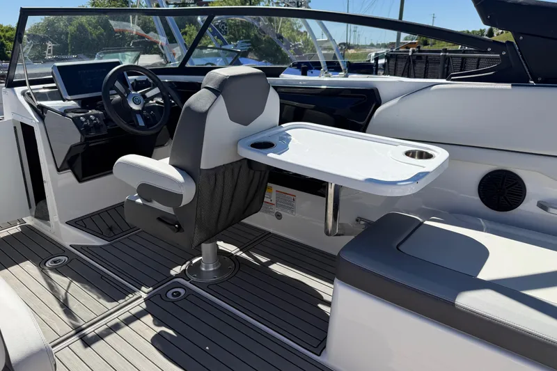 Slide: The Image of 2023 Yamaha Boats AR250 interior with steering wheel, seating, and table setup. - 31