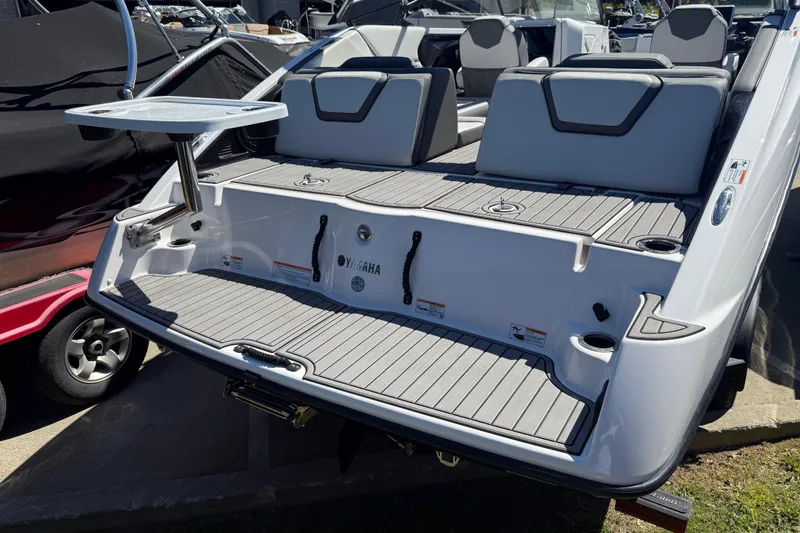 Slide: The Image of 2023 Yamaha Boats AR250 rear deck with seating and table setup. - 35