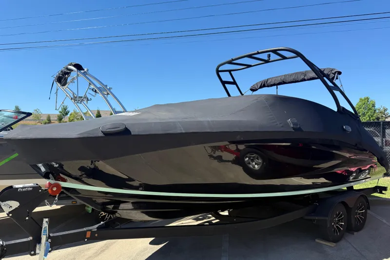Slide: The Image of 2023 Yamaha Boats AR250 covered on trailer, parked outdoors under clear sky. - 5