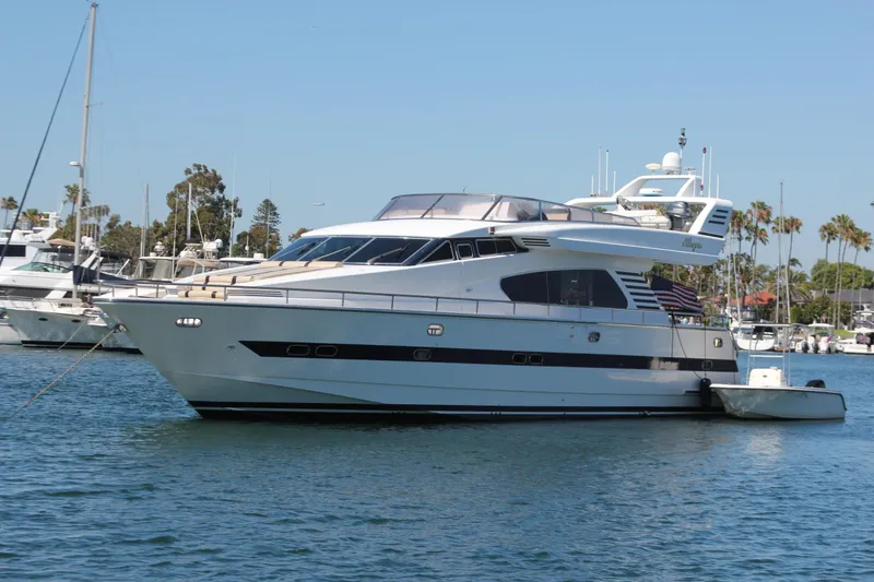 The Image of 1999 Horizon 70 Motor Yacht on calm water, surrounded by other boats and palm trees. - 0