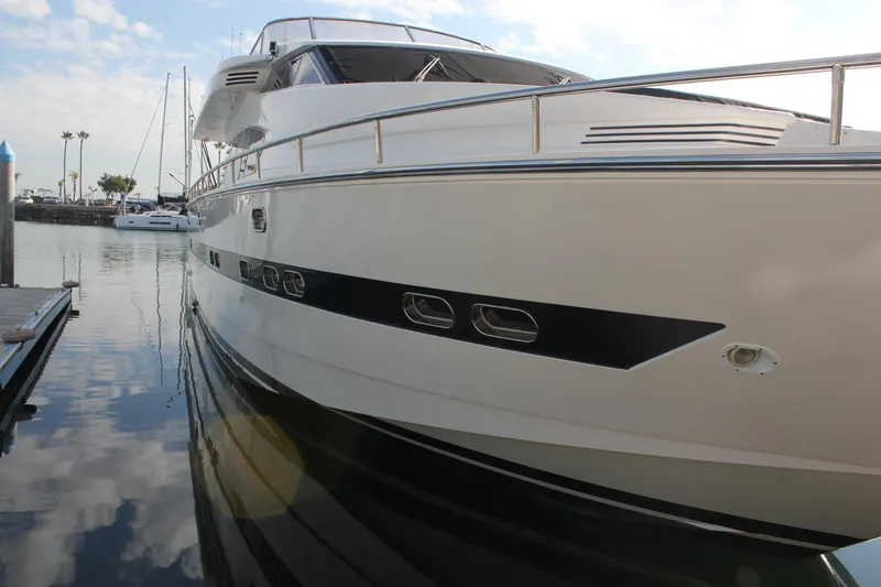 Slide: The Image of 1999 Horizon 70 Motor Yacht docked in a serene marina setting. - 13