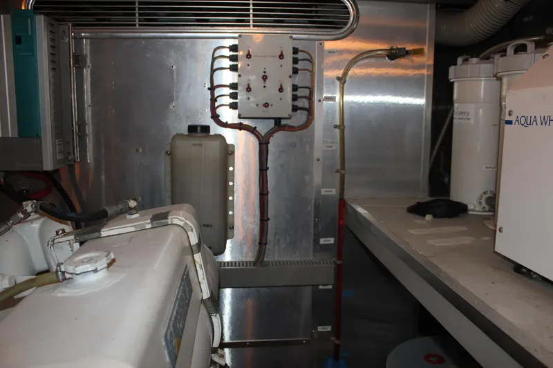 Slide: The Image of Engine room of 1999 Horizon 70 Motor Yacht with mechanical equipment and control panel. - 28