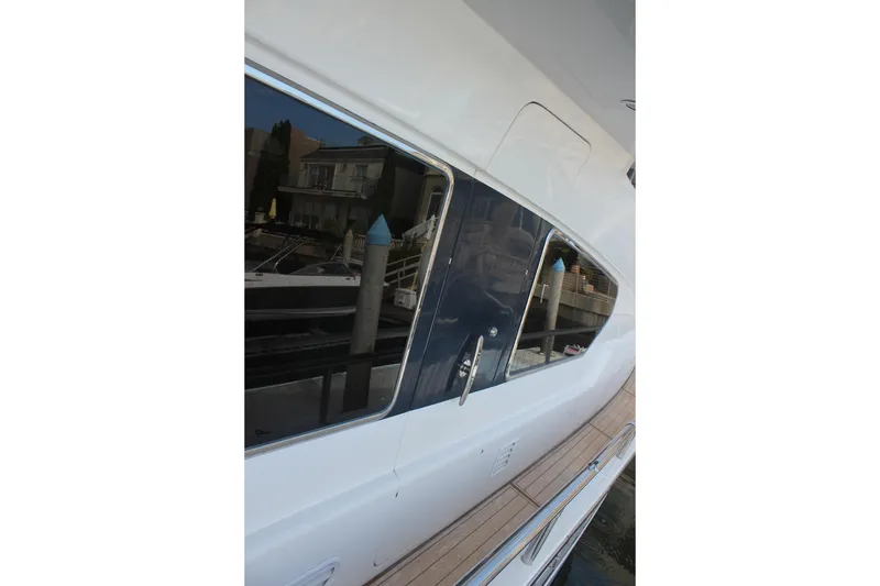 Slide: The Image of Side view of a 1999 Horizon 70 Motor Yacht docked at a marina. - 58
