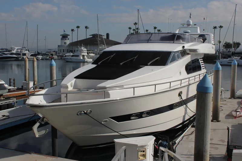 Slide: The Image of 1999 Horizon 70 Motor Yacht docked at a marina under a partly cloudy sky. - 6