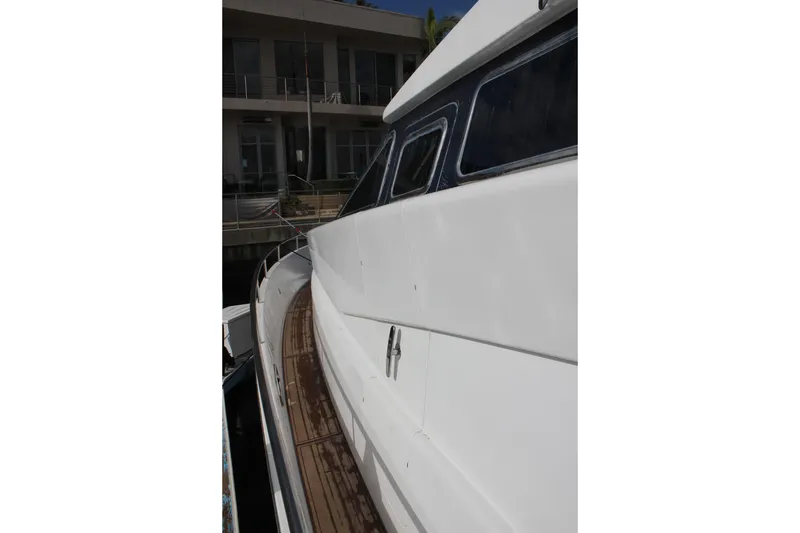 Slide: The Image of Side view of a 1999 Horizon 70 Motor Yacht with sleek white exterior. - 62