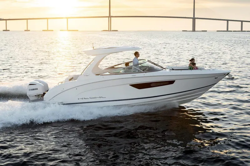 The Image of Manufacturer Provided Image: 2026 Regal 33 OBX boat cruising on water at sunset near a bridge. - 0