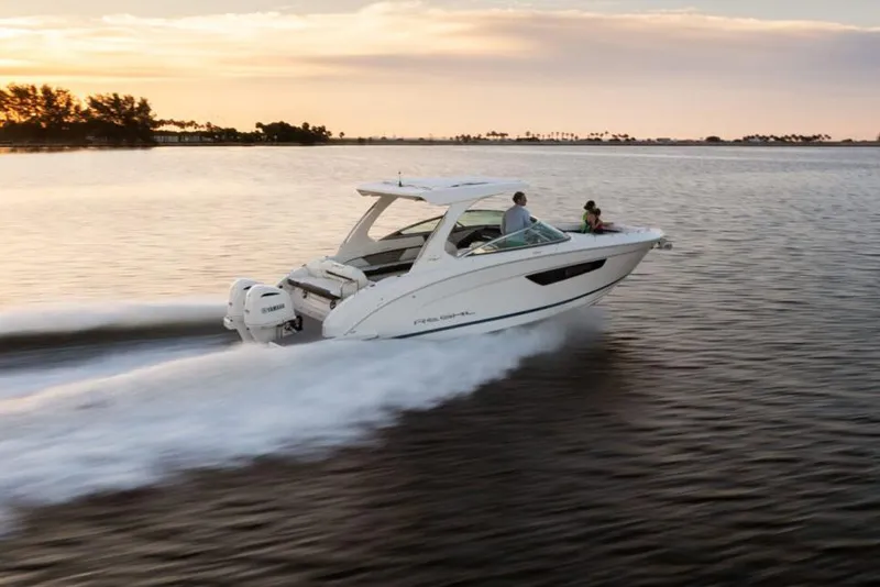 Slide: The Image of Manufacturer Provided Image: 2026 Regal 33 OBX boat cruising on a serene lake at sunset. - 2