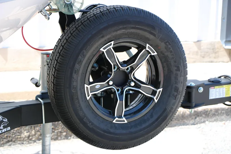 Slide: The Image of 2025 Chaparral 21 SSi Ski & Fish trailer wheel, black alloy rim, radial tire. - 17