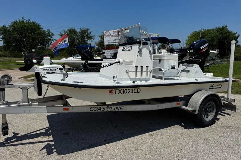 Slide: The Image of 2014 Mowdy 13 Scooter boat on trailer, featuring Suzuki motor and Minn Kota trolling motor. - 13