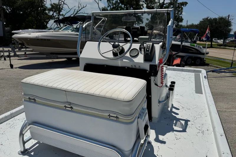 Slide: The Image of 2014 Mowdy 13 Scooter boat interior with steering console and cushioned seat. - 9