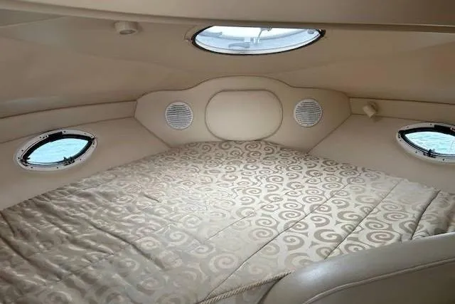 Slide: The Image of Cozy cabin interior of 2003 Maxum 2900 SCR boat with patterned bedding and portholes. - 10