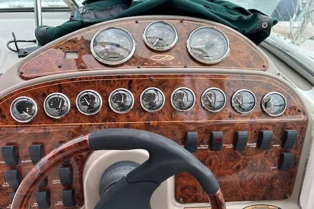 Slide: The Image of 2003 Maxum 2900 SCR boat dashboard with wood finish and multiple gauges. - 2