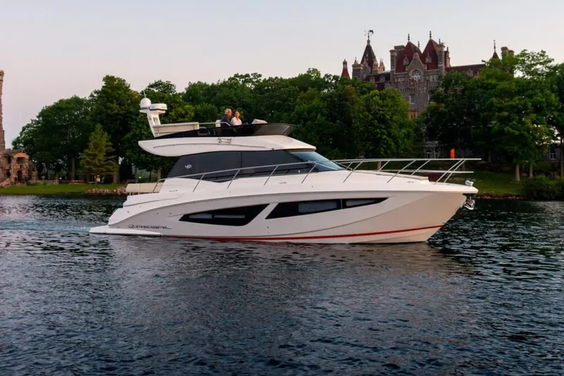 Slide: The Image of Manufacturer Provided Image: 2026 Regal 42 Fly yacht cruising on a serene lake with a historic building backdrop. - 2