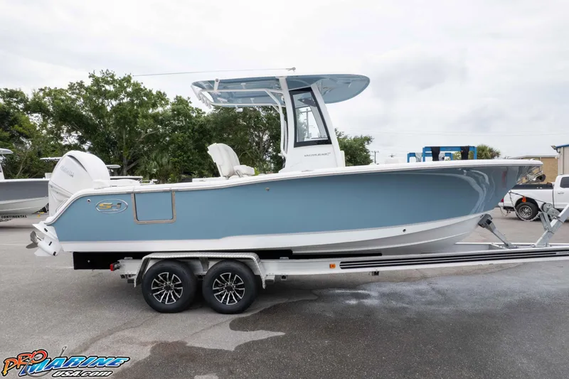 Slide: The Image of 2026 Sea Hunt Ultra 245 SE boat on trailer, side view, blue and white design. - 15