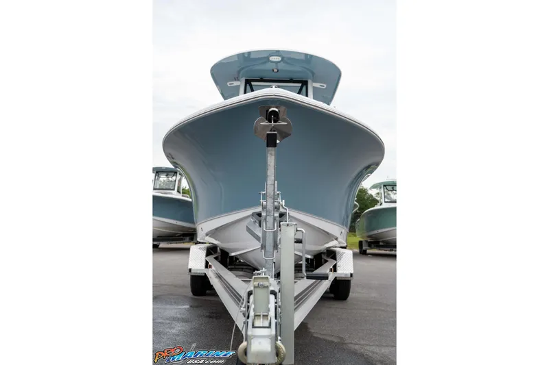 Slide: The Image of 2026 Sea Hunt Ultra 245 SE boat on trailer, front view, parked outdoors. - 23