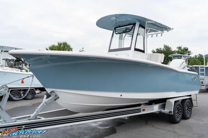 Slide: The Image of 2026 Sea Hunt Ultra 245 SE boat on trailer, featuring sleek blue and white design. - 26
