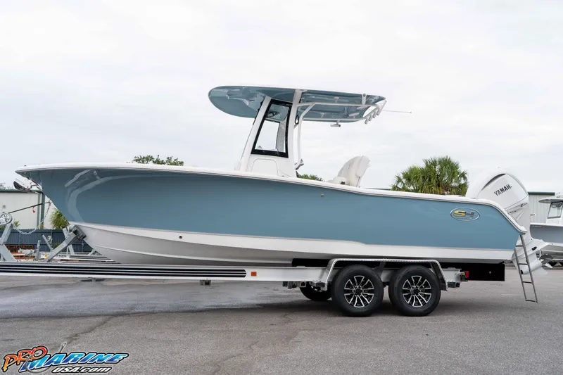Slide: The Image of 2026 Sea Hunt Ultra 245 SE boat on trailer, side view, blue and white design. - 27
