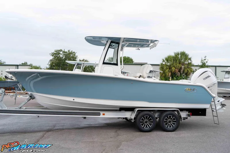 Slide: The Image of 2026 Sea Hunt Ultra 245 SE boat on trailer, side view, blue and white design. - 28