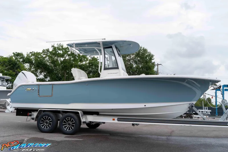 Slide: The Image of 2026 Sea Hunt Ultra 245 SE boat on trailer, side view, blue hull, outdoors. - 32