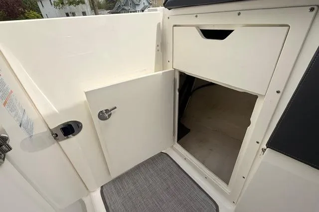 Slide: The Image of 2019 Chaparral 277 SSX boat interior storage compartment with open door. - 16