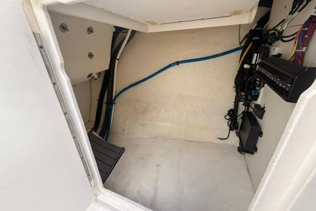 Slide: The Image of Interior view of 2019 Chaparral 277 SSX boat compartment with wiring and storage space. - 17