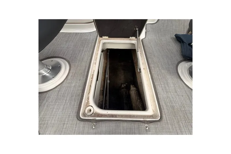 Slide: The Image of 2019 Chaparral 277 SSX boat storage compartment with open hatch on gray flooring. - 28
