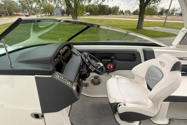 Slide: The Image of 2019 Chaparral 277 SSX boat cockpit with steering wheel and white captain's chair. - 7