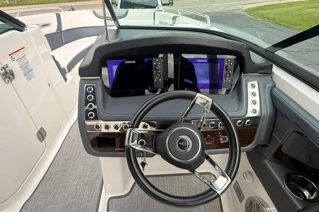 Slide: The Image of 2019 Chaparral 277 SSX boat dashboard with dual Simrad displays and modern steering wheel. - 8