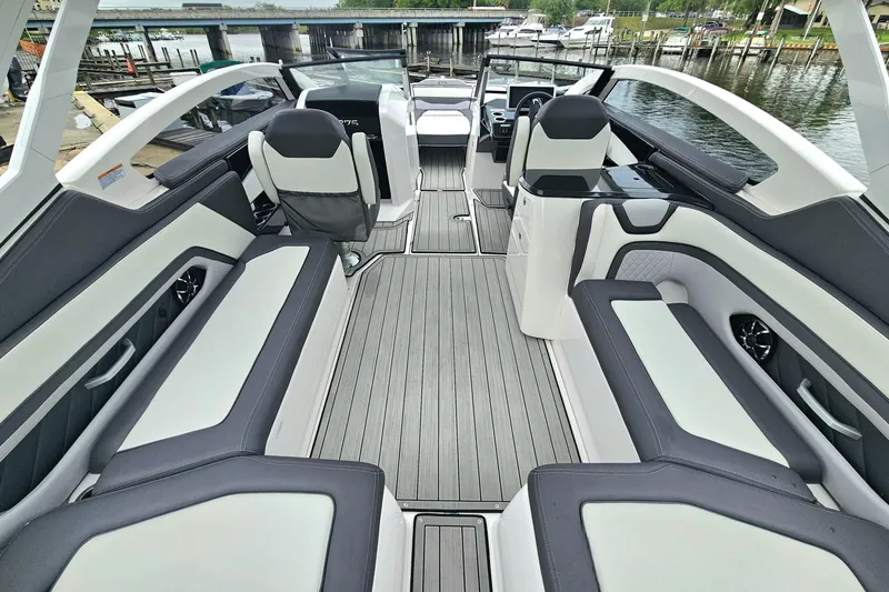 Slide: The Image of 2023 Yamaha Boats 275SDX interior with sleek seating and modern design by the water. - 11