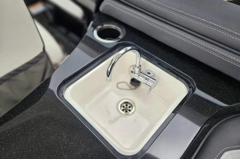 Slide: The Image of 2023 Yamaha Boats 275SDX sink with chrome faucet and cup holder. - 17
