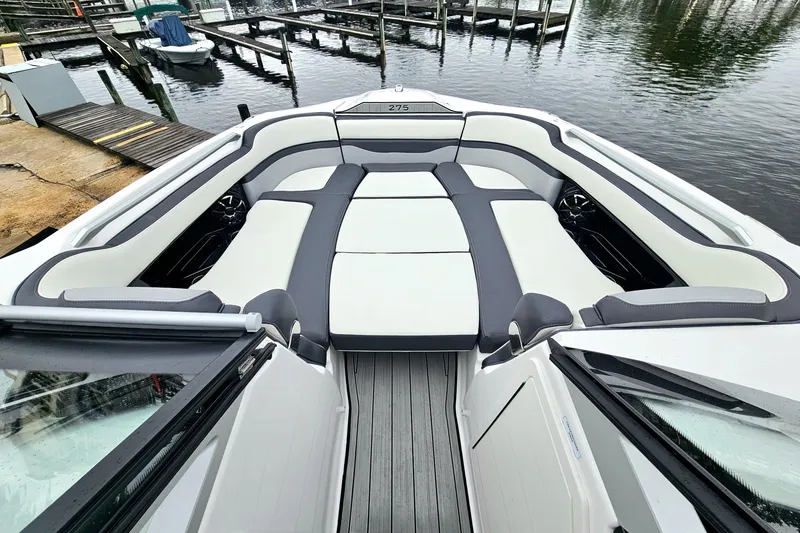 Slide: The Image of 2023 Yamaha Boats 275SDX interior with spacious seating at a marina. - 23