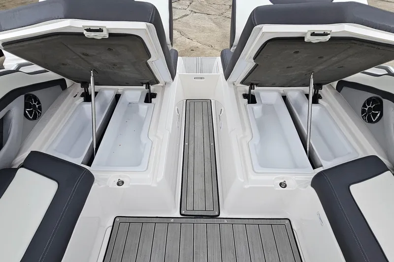 Slide: The Image of 2023 Yamaha Boats 275SDX interior storage compartments with open seats and sleek design. - 36