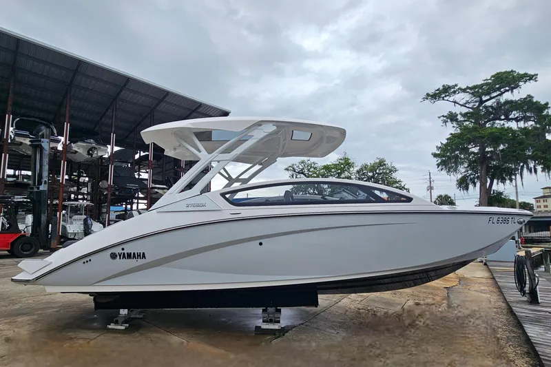 Slide: The Image of 2023 Yamaha Boats 275SDX on display at a marina under cloudy skies. - 6