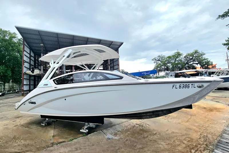 Slide: The Image of 2023 Yamaha Boats 275SDX on display, sleek design, white exterior, parked outdoors. - 7