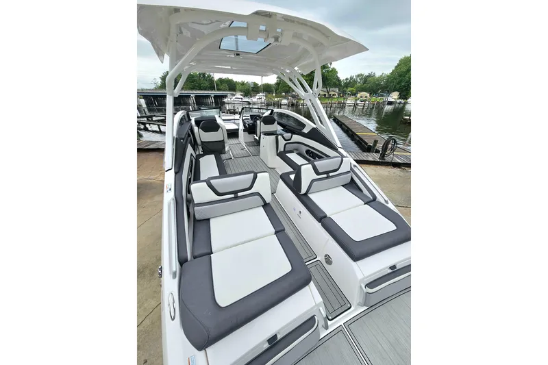 Slide: The Image of 2023 Yamaha Boats 275SDX interior with sleek seating at a marina dock. - 8