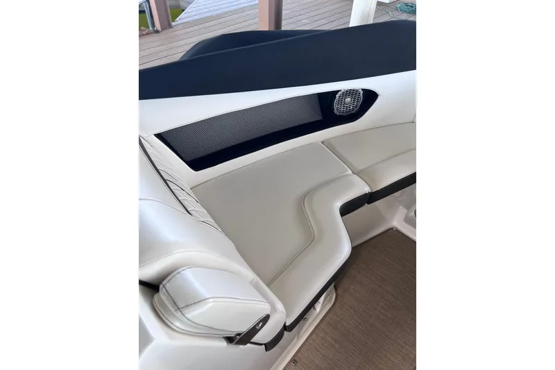 Slide: The Image of Interior seating of 2018 Sea Ray SLX 250 boat, featuring white upholstery and speaker. - 13