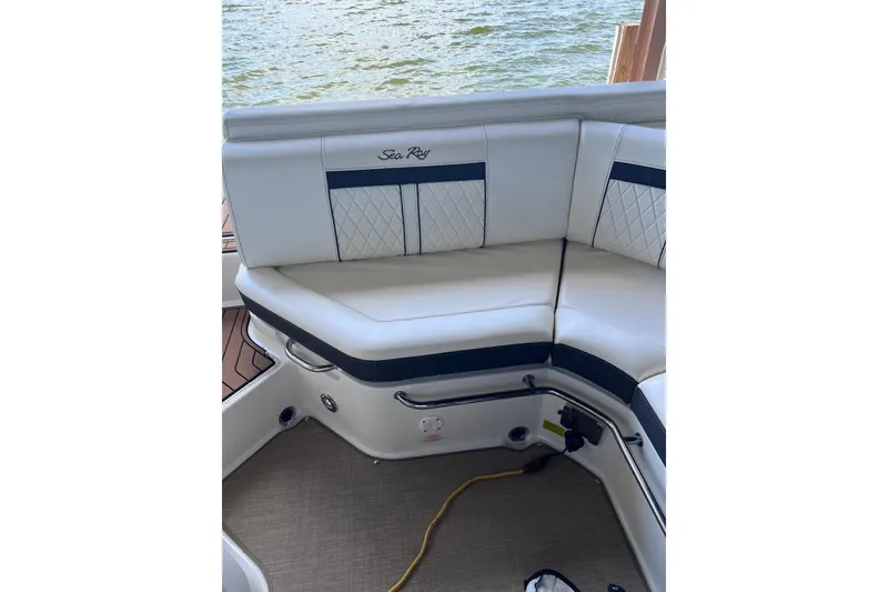 Slide: The Image of 2018 Sea Ray SLX 250 boat interior with white cushioned seating by the water. - 15