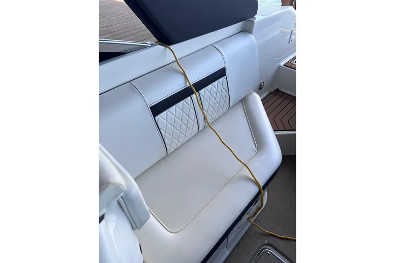 Slide: The Image of 2018 Sea Ray SLX 250 boat interior with white leather seating and decorative stitching. - 16