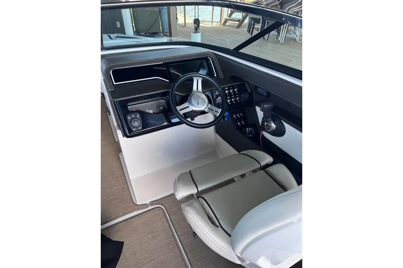 Slide: The Image of 2018 Sea Ray SLX 250 helm with steering wheel and control panel. - 18