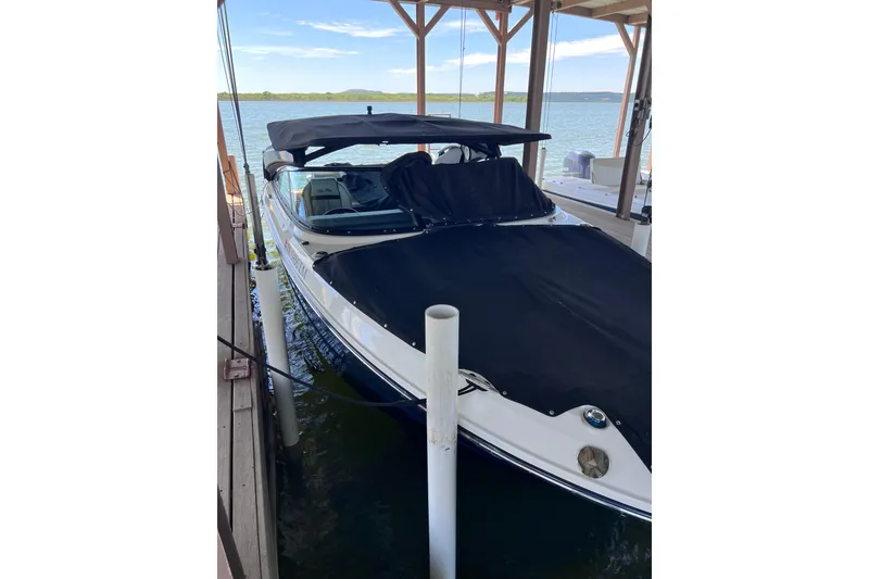 Slide: The Image of 2018 Sea Ray SLX 250 boat docked with black cover and canopy. - 4