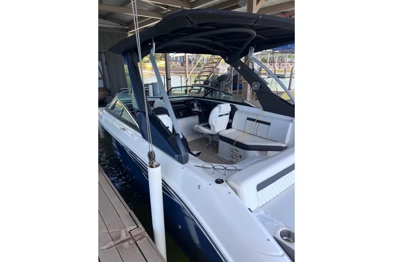 Slide: The Image of 2018 Sea Ray SLX 250 boat docked, featuring sleek design and spacious seating. - 5