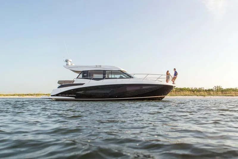 Slide: The Image of Manufacturer Provided Image: 2026 Regal 42 Grande Coupe yacht cruising on open water with two people on deck. - 3