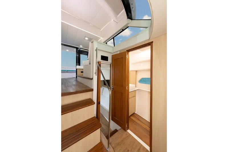 Slide: The Image of Manufacturer Provided Image: Interior view of 2026 Regal 42 Grande Coupe yacht, featuring wooden stairs and cabin access. - 8