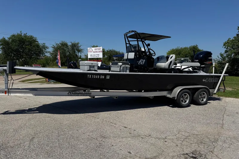 The Image of 2016 El Pescador 24 CAT boat on trailer, parked outdoors under clear blue sky. - 1