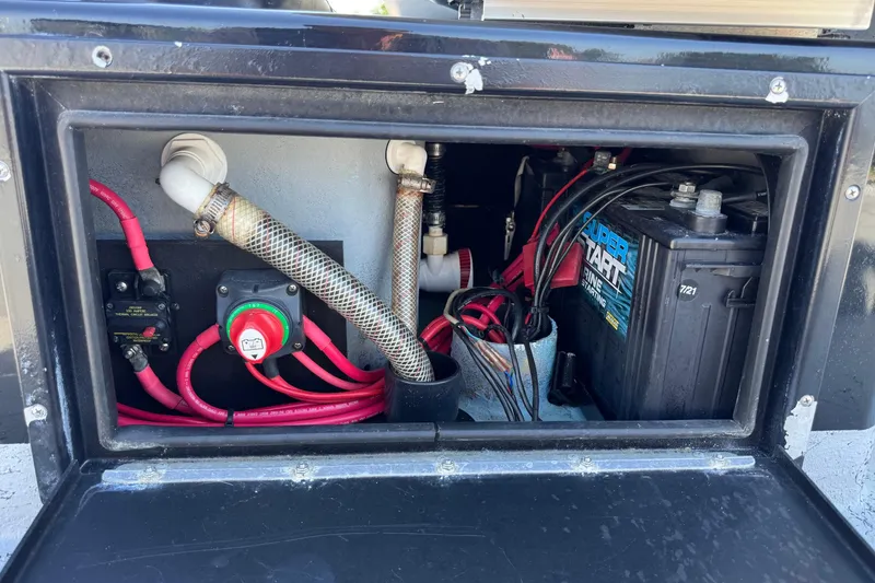 Slide: The Image of Electrical compartment of a 2016 El Pescador 24 CAT boat, featuring wiring and battery setup. - 18