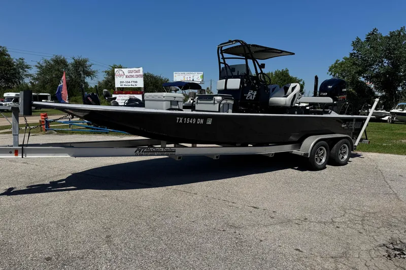 Slide: The Image of 2016 El Pescador 24 CAT boat on trailer, parked outdoors under clear sky. - 2