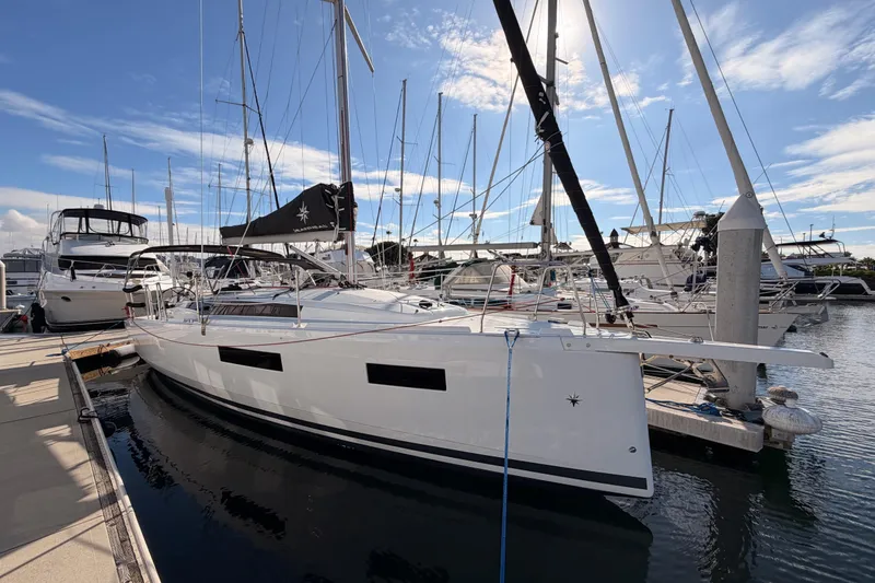 Slide: The Image of 2025 Jeanneau Sun Odyssey 350 sailboat docked at marina under clear blue sky. - 1