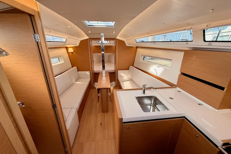 Slide: The Image of Luxurious interior of 2025 Jeanneau Sun Odyssey 350 sailboat, featuring modern kitchen and seating. - 52