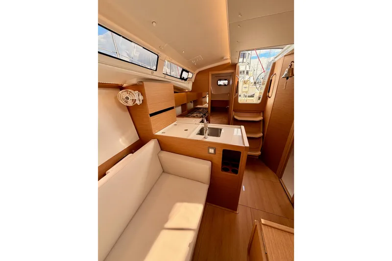 Slide: The Image of Interior of 2025 Jeanneau Sun Odyssey 350 sailboat, featuring modern wood finish and compact kitchen. - 87