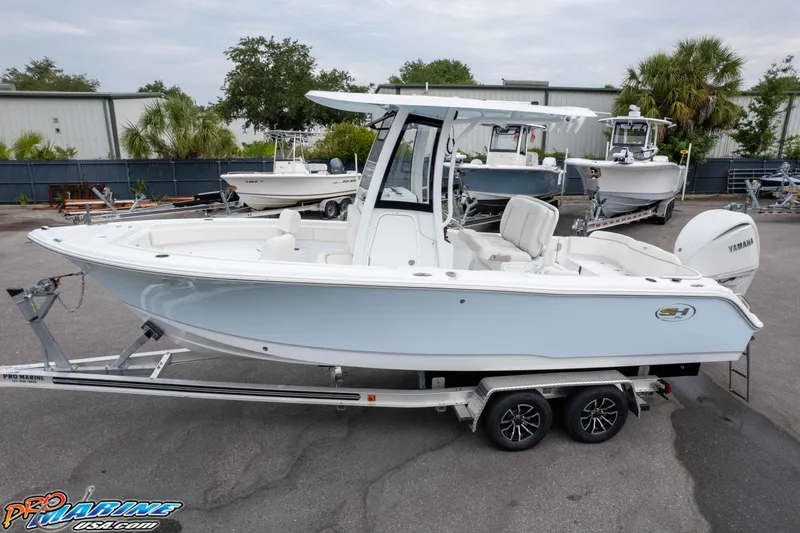 Slide: The Image of 2026 Sea Hunt Ultra 235 SE boat on trailer, displayed outdoors with other boats. - 12